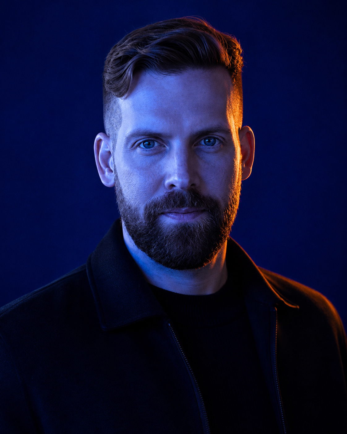 Brett Ryckman, lit in cobalt and orange